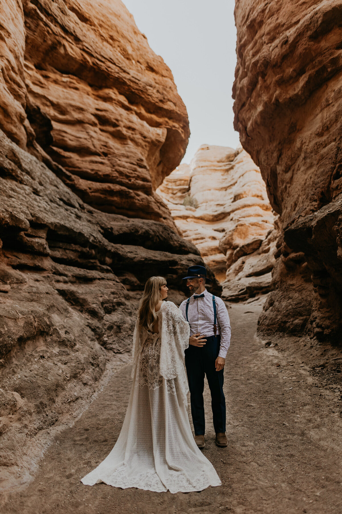 bride and groom standing together in a slot canyon
