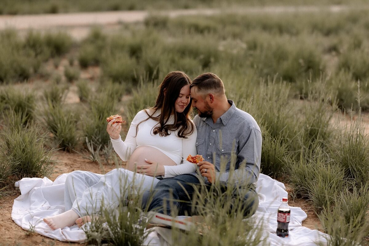 couple sitting on blanket enjoying the fresh air and  the last few weeks of her pregnancy