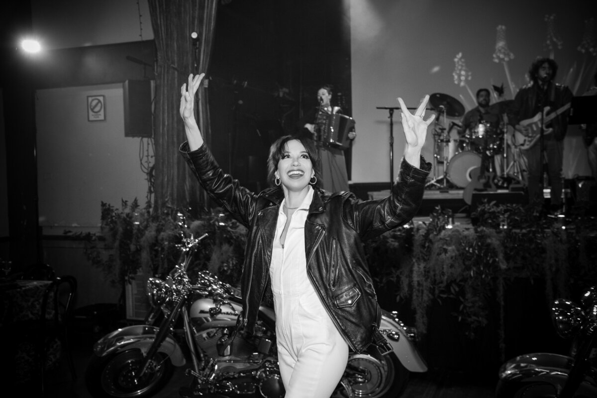 A bride enters her wedding reception on a motorcycle