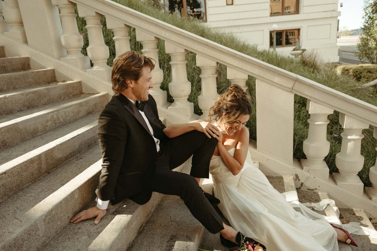 Newlyweds lounge on the city hall steps following their elopement. Photographed by Wilder Photography.