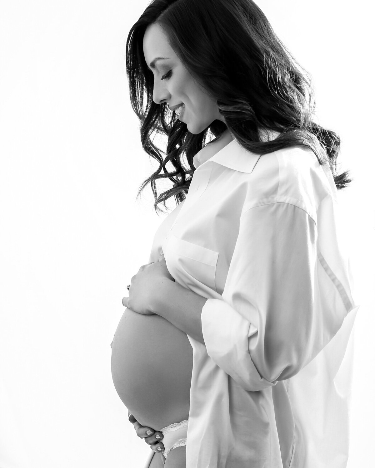 Black and white Maternity portrait of a woman wearing her husband's shirt