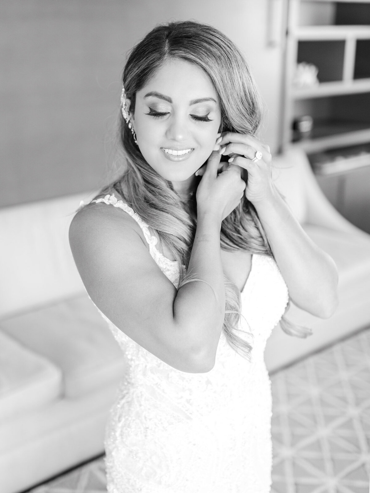 A black-and-white close-up of the bride adjusting her earring as she prepares for her wedding day at the Ritz-Carlton Laguna Niguel