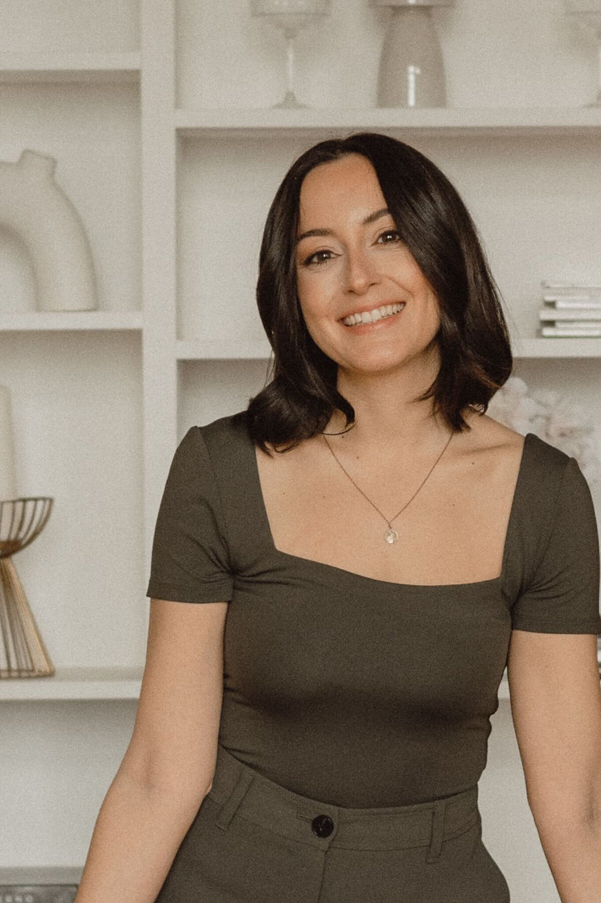 Vickie of VERVE & COLOR in olive green attire embodying a relaxed and professional vibe for her web design brand.