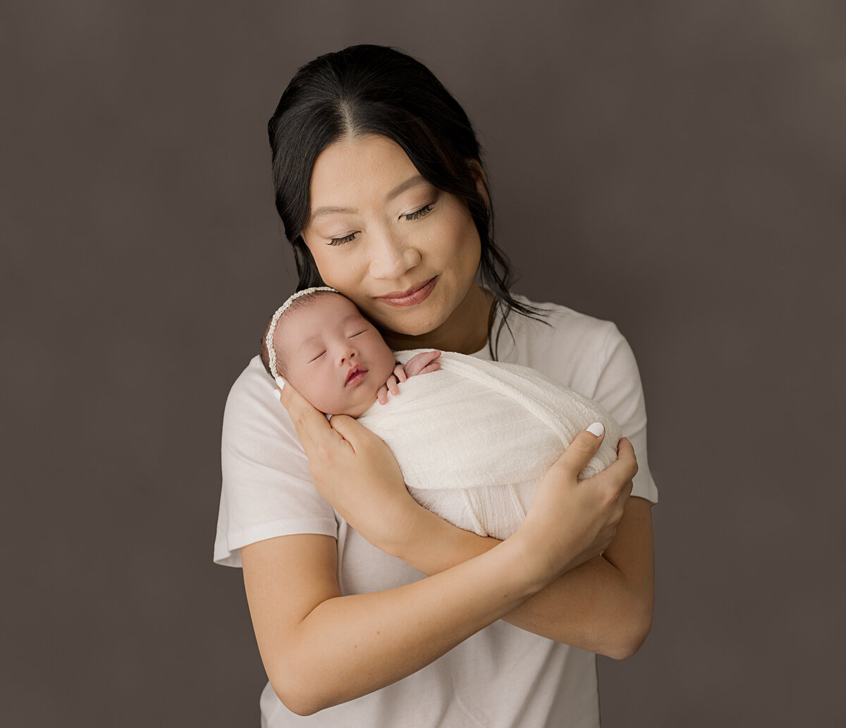mom holding newborn with eyes closed