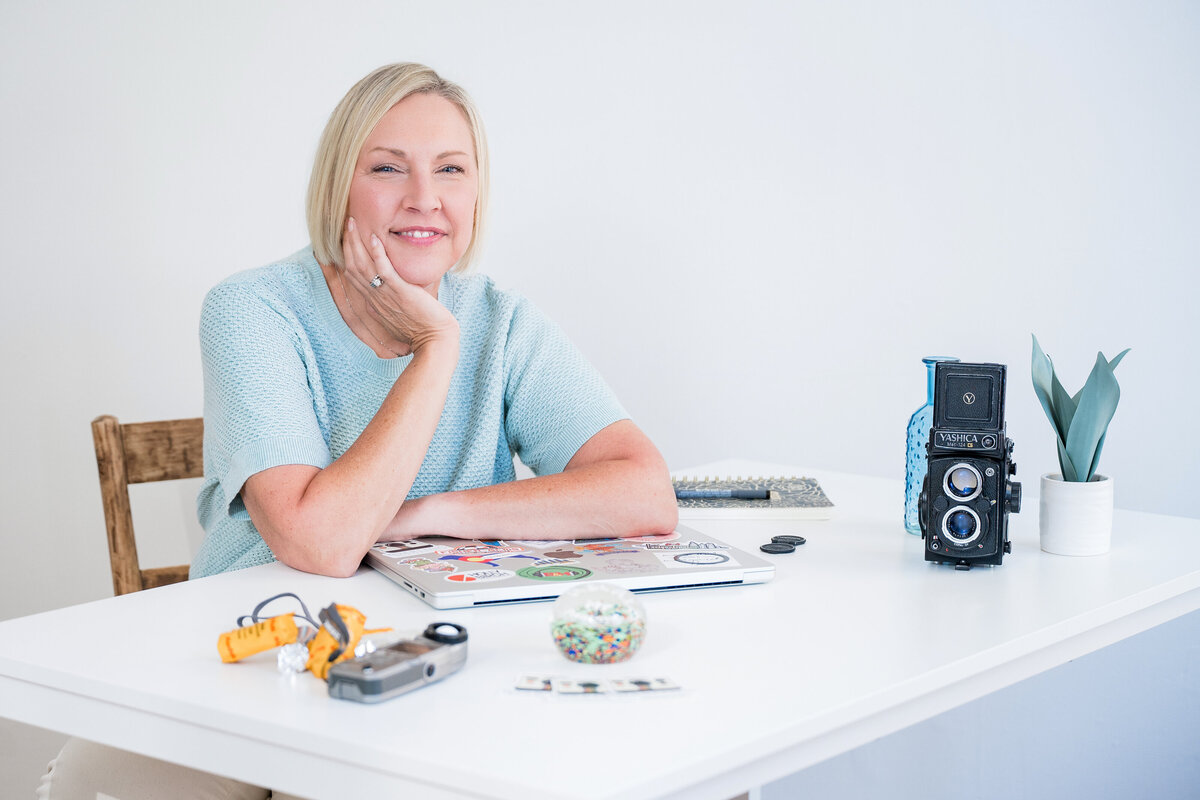 Kristin Darling working on photography planning with a Hasselblad camera and laptop in her Central Illinois studio