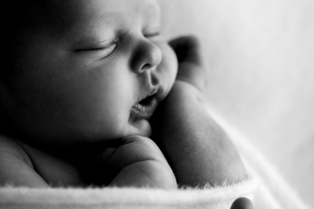 Macro photo of a baby boy squishing his cheeks.