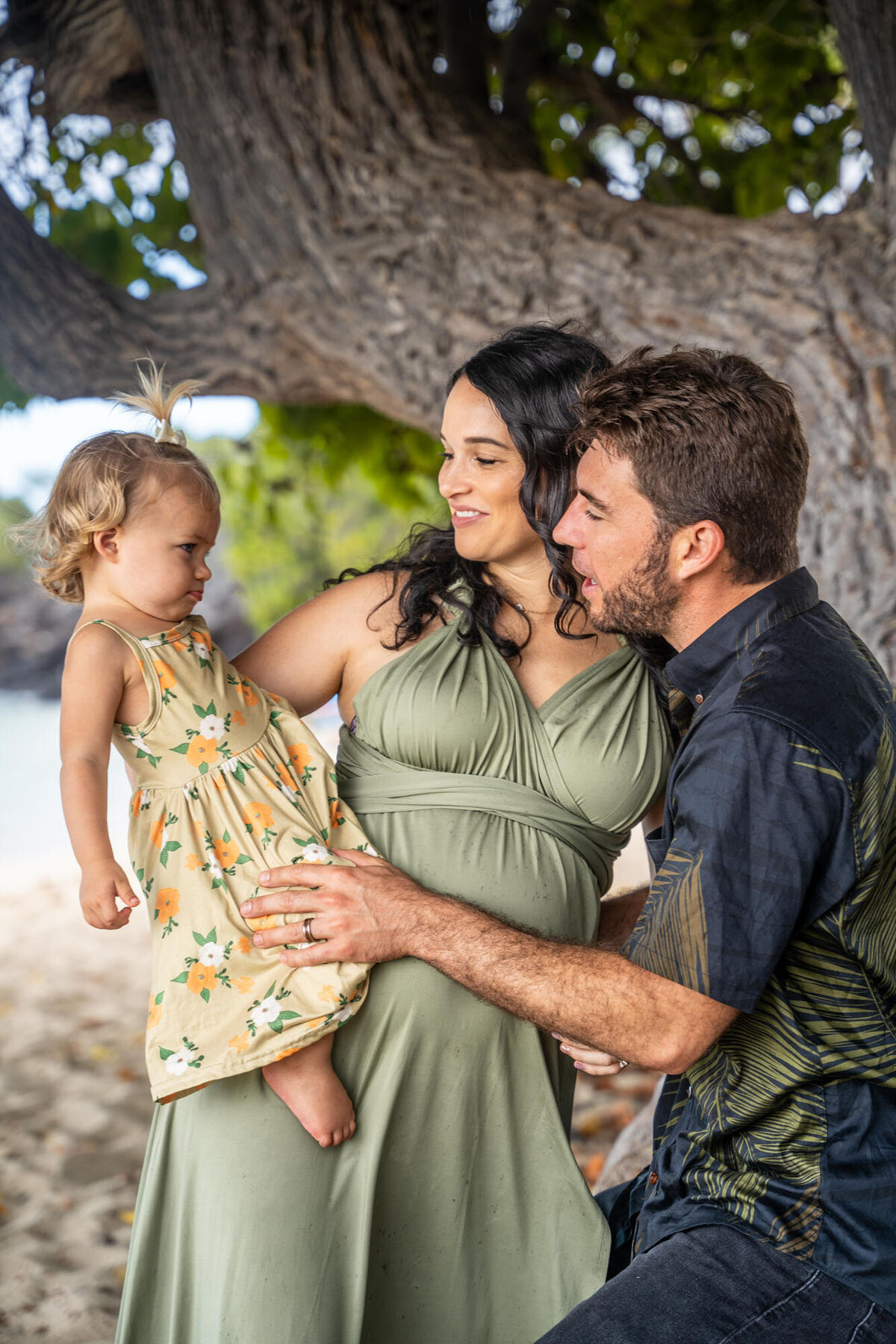 Parents looking at daughter under a tree, taken by Hawaii adventure portraits, big island family photographer