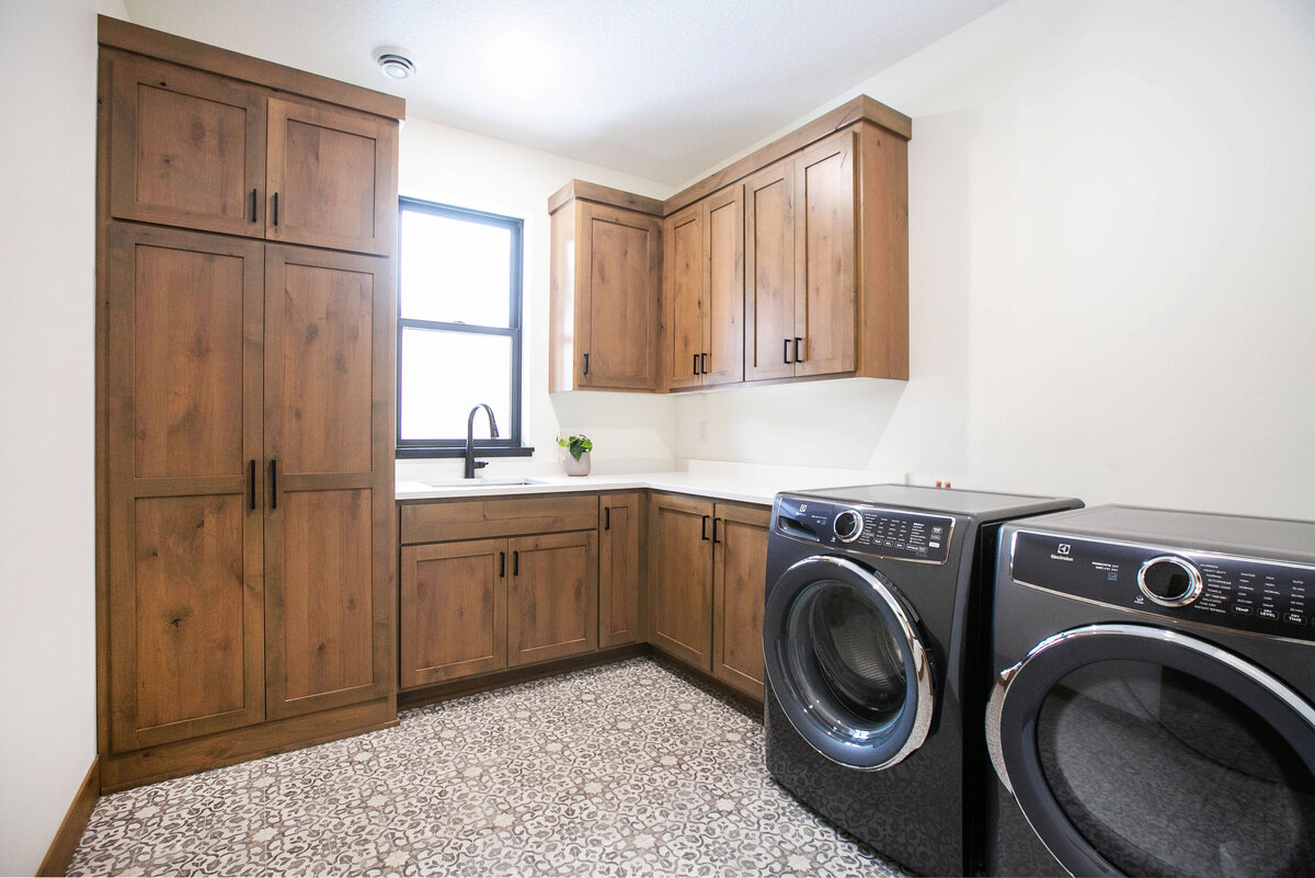 Custom Laundry Room with wood flooring and dark cabinets in a custom-built Elk River home