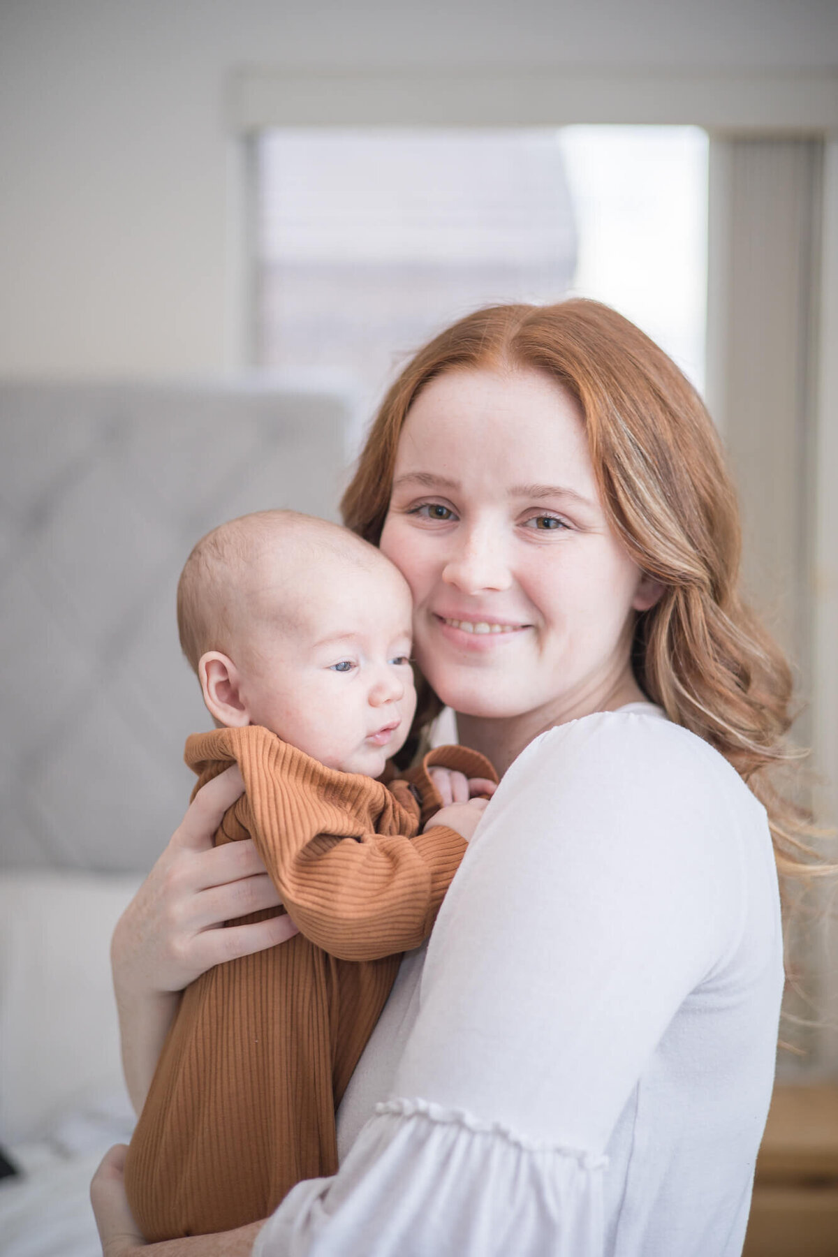 redheaded mom holding her infant son close