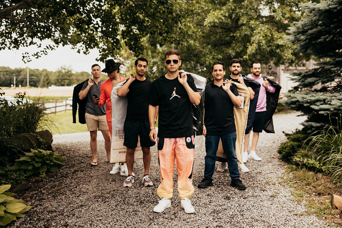 a groom and his groomsmen arriving with their suits to get ready for their wedding in the preparation cottage at Willowbrook wedding venue in Volant, PA