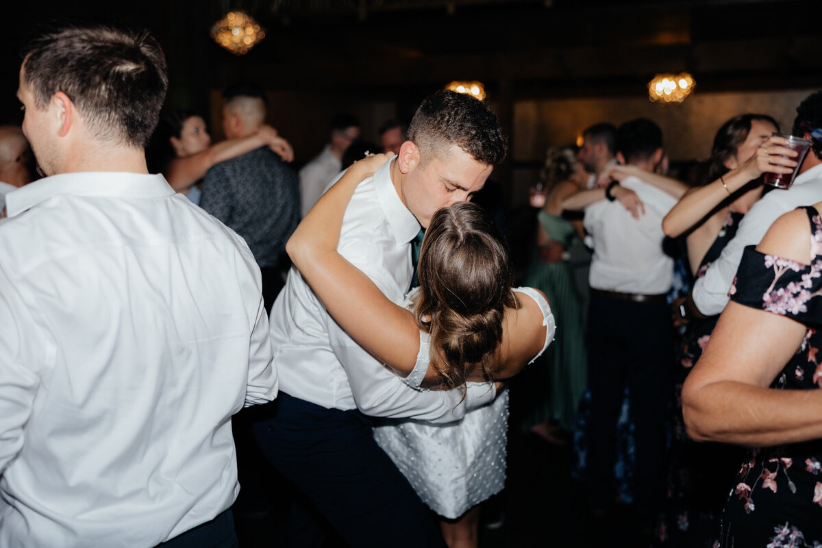 Joyful guests moving to music on open-air lodge dance floor
