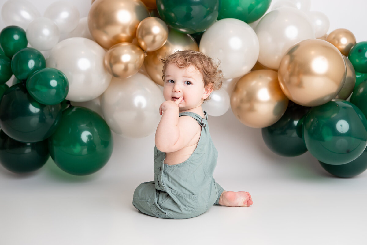 Edmonton baby boy first birthday cake smash green gold white balloon garland