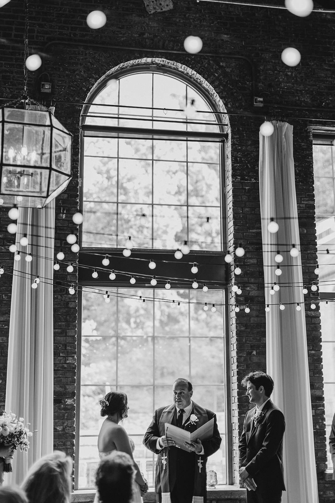 String lights hanging over a couple during their wedding ceremony 