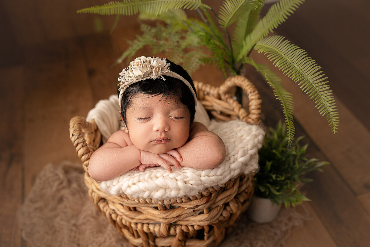 stunning boho style newborn photography captures baby girl in bamboo basket