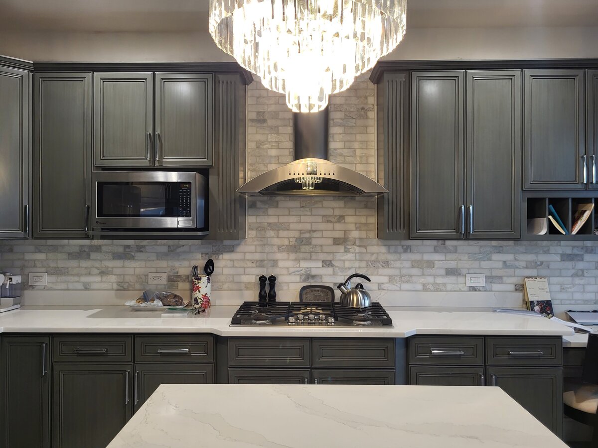 kitchen and stovetop with marble tiled backsplash with silestone counters and a green grey washed cabinets