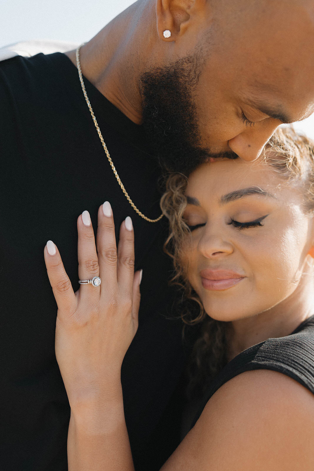 Close up of an engagement ring as the couple snuggles