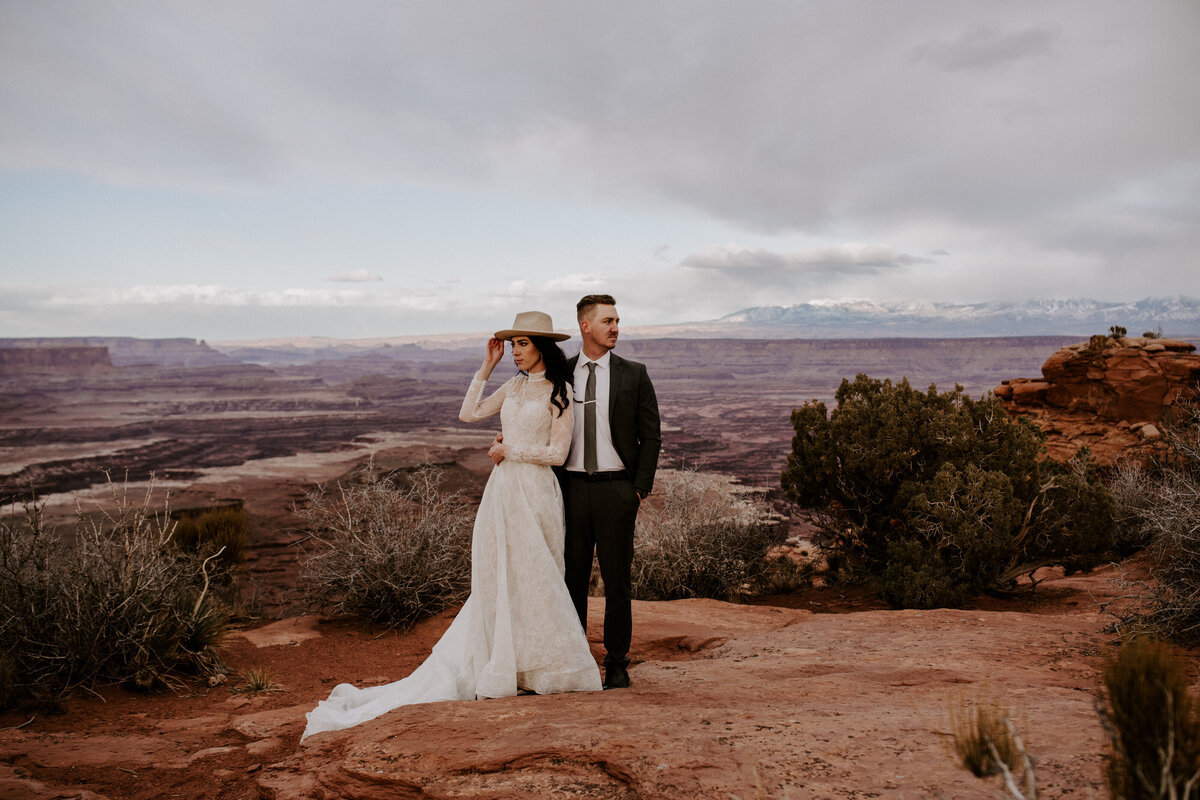 Bride and groom standing on the edge of a canyon