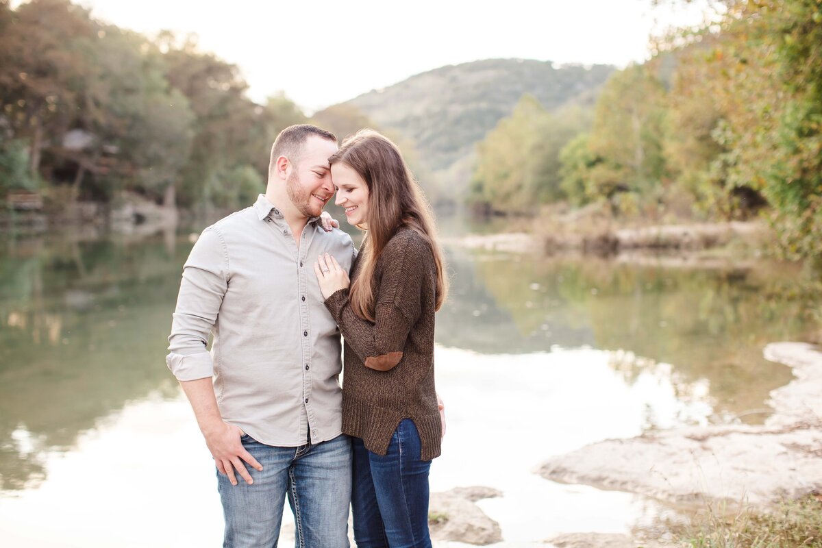winter sweater by river at golden hour engagement session by Texas wedding photographer Firefly