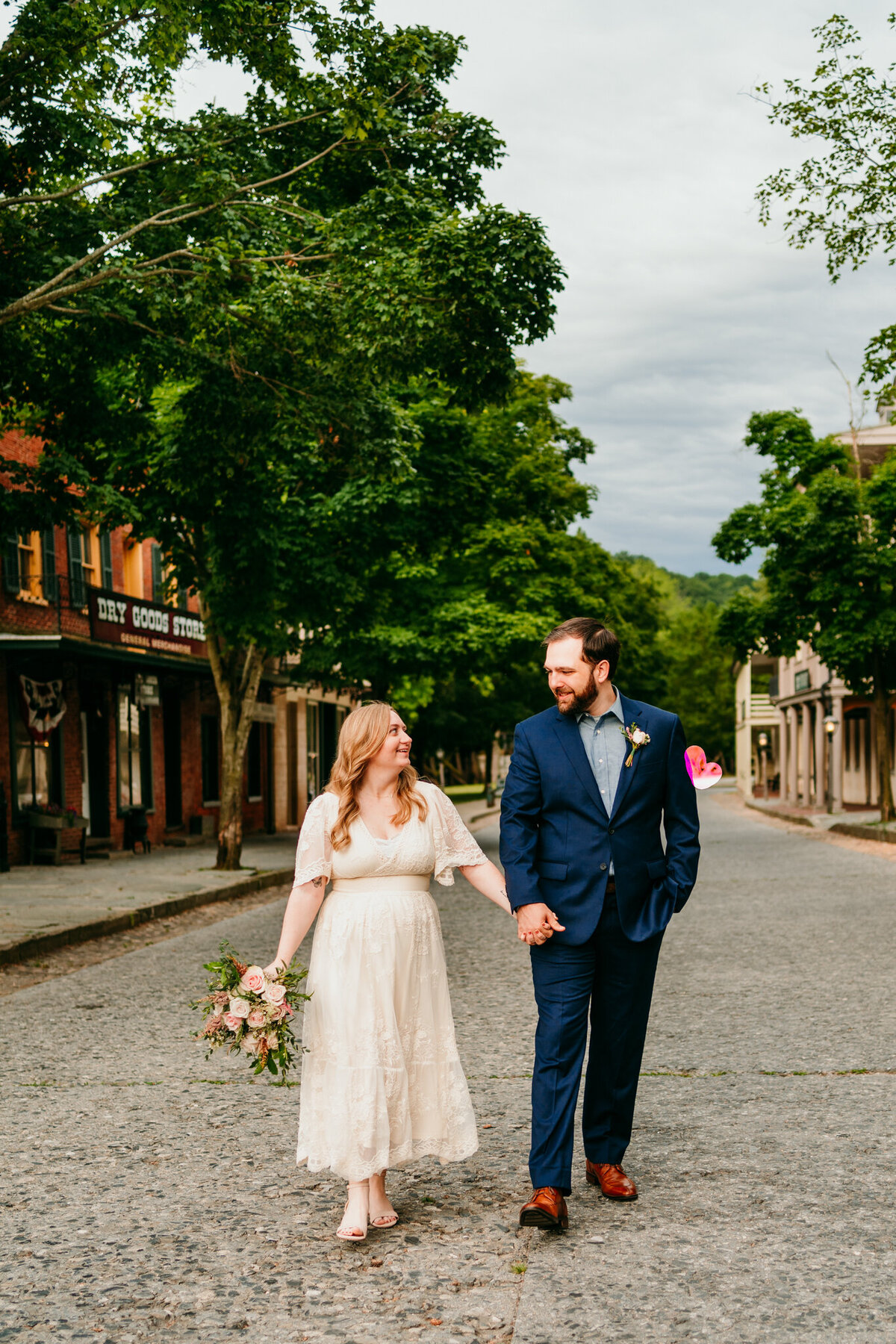 Couple walking hand in hand down historic cobblestone street