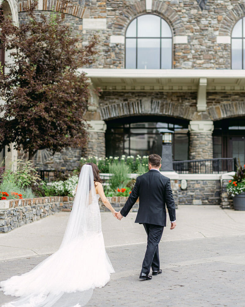 This beautiful photograph captures the bride and groom walking hand in hand towards the VIP entrance of the Banff Springs Hotel. The iconic hotel and elegant setting enhance the couple’s love and excitement on their wedding day.