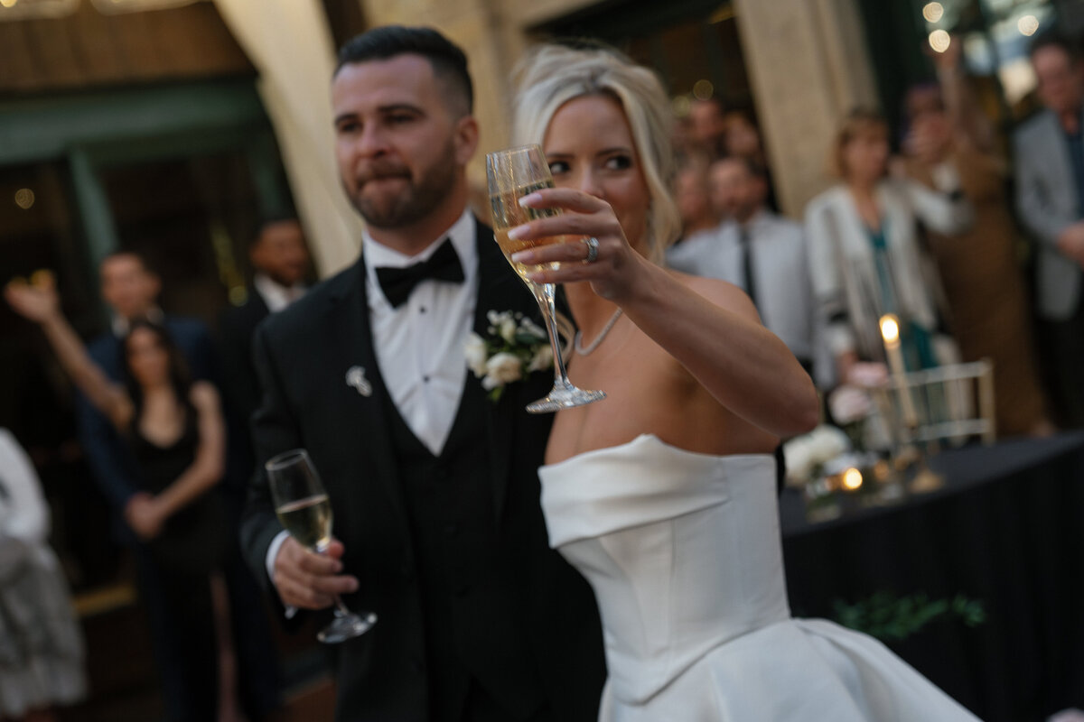 bride and groom making a toast with champagne glasses at wedding reception by east coast photographer shelby ann photos
