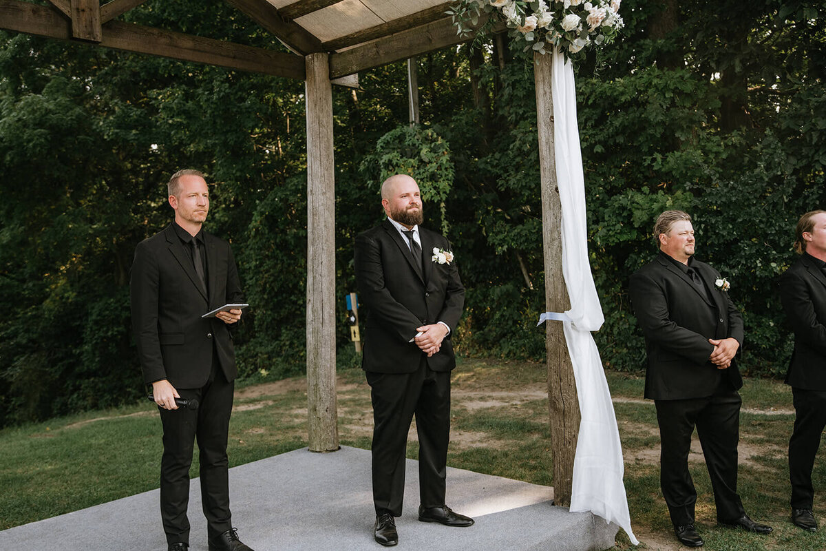 Groom-standing-at-alter