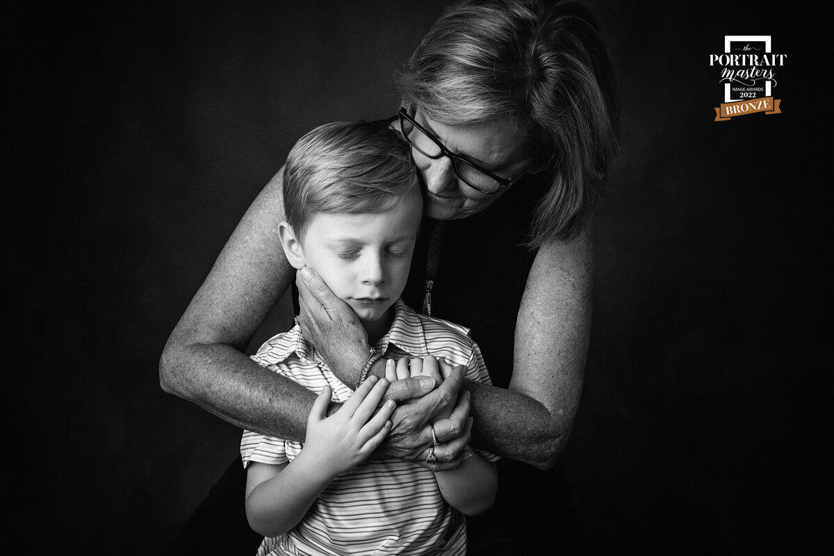 Family Photographer, a mother holds her young son next to her