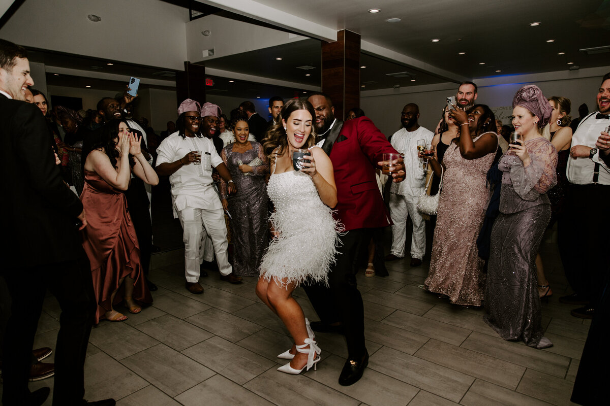 A couple laughs while dancing on the dance floor while everyone parties around them at The Lotus House.