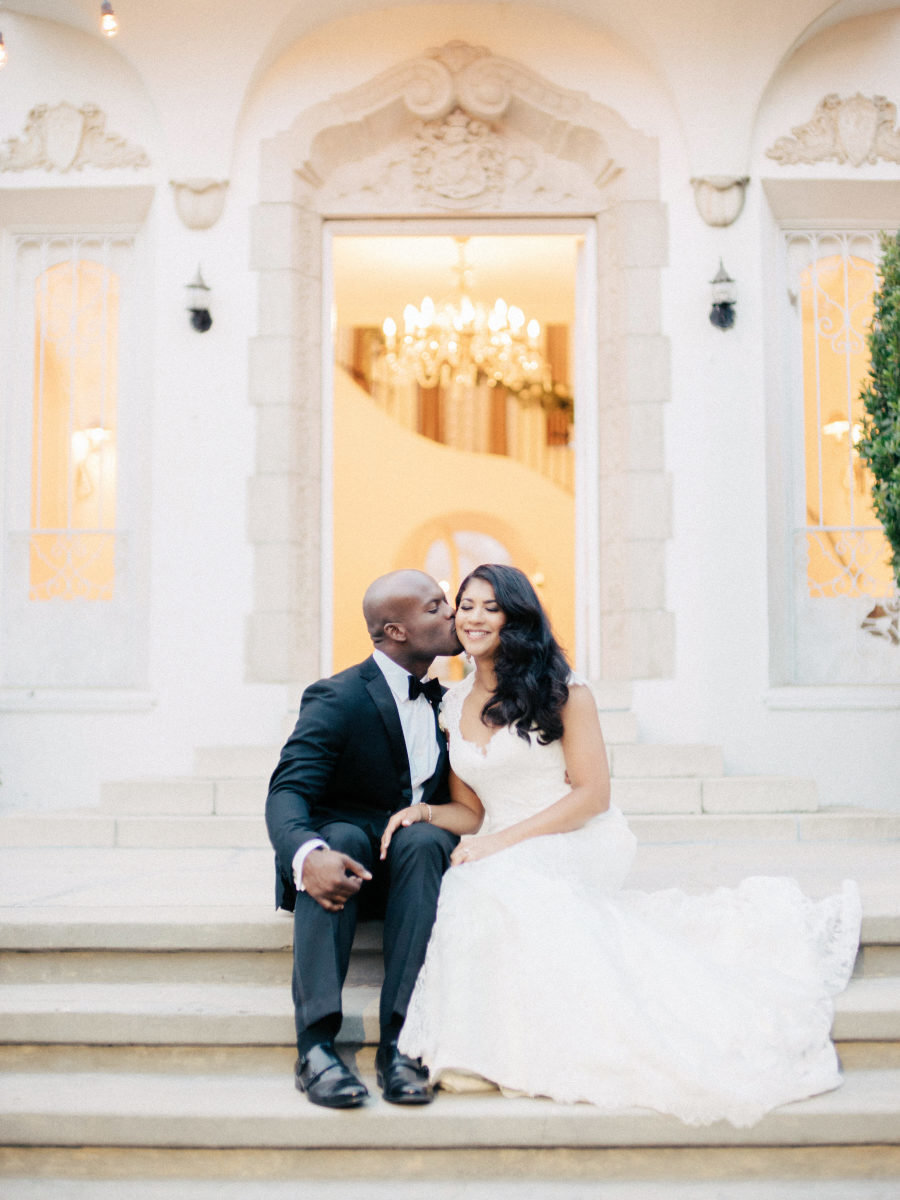 bride and groom kissing on the mansion steps