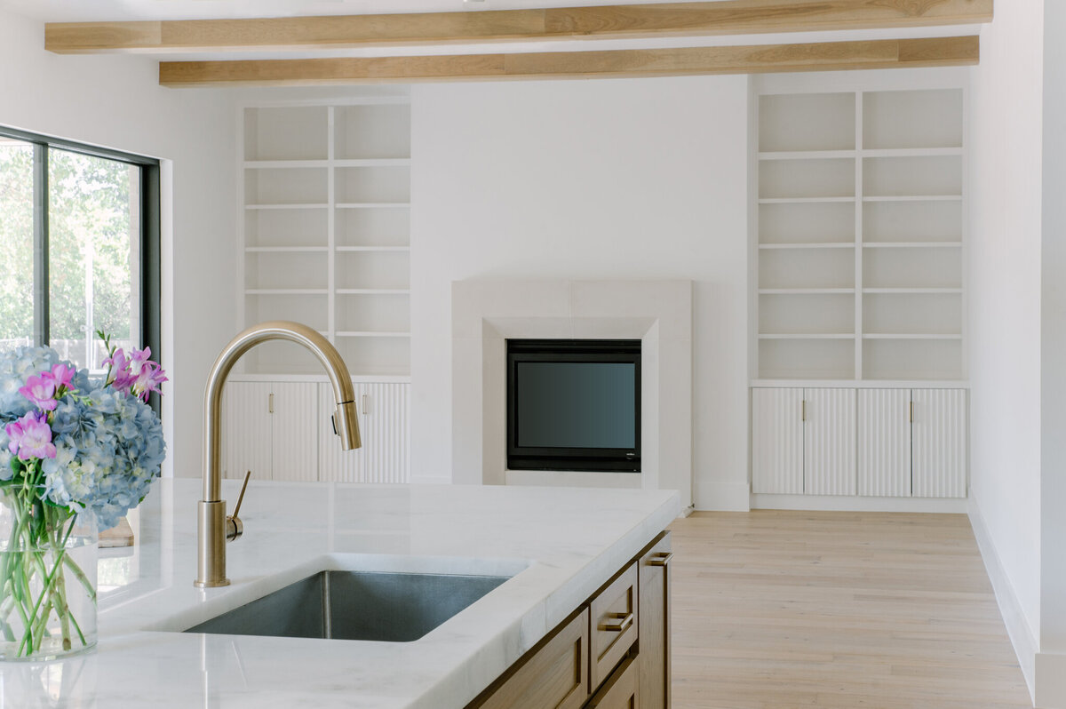 Kitchen and living area of a modern newly constructed  home with beams flanking the ceiling