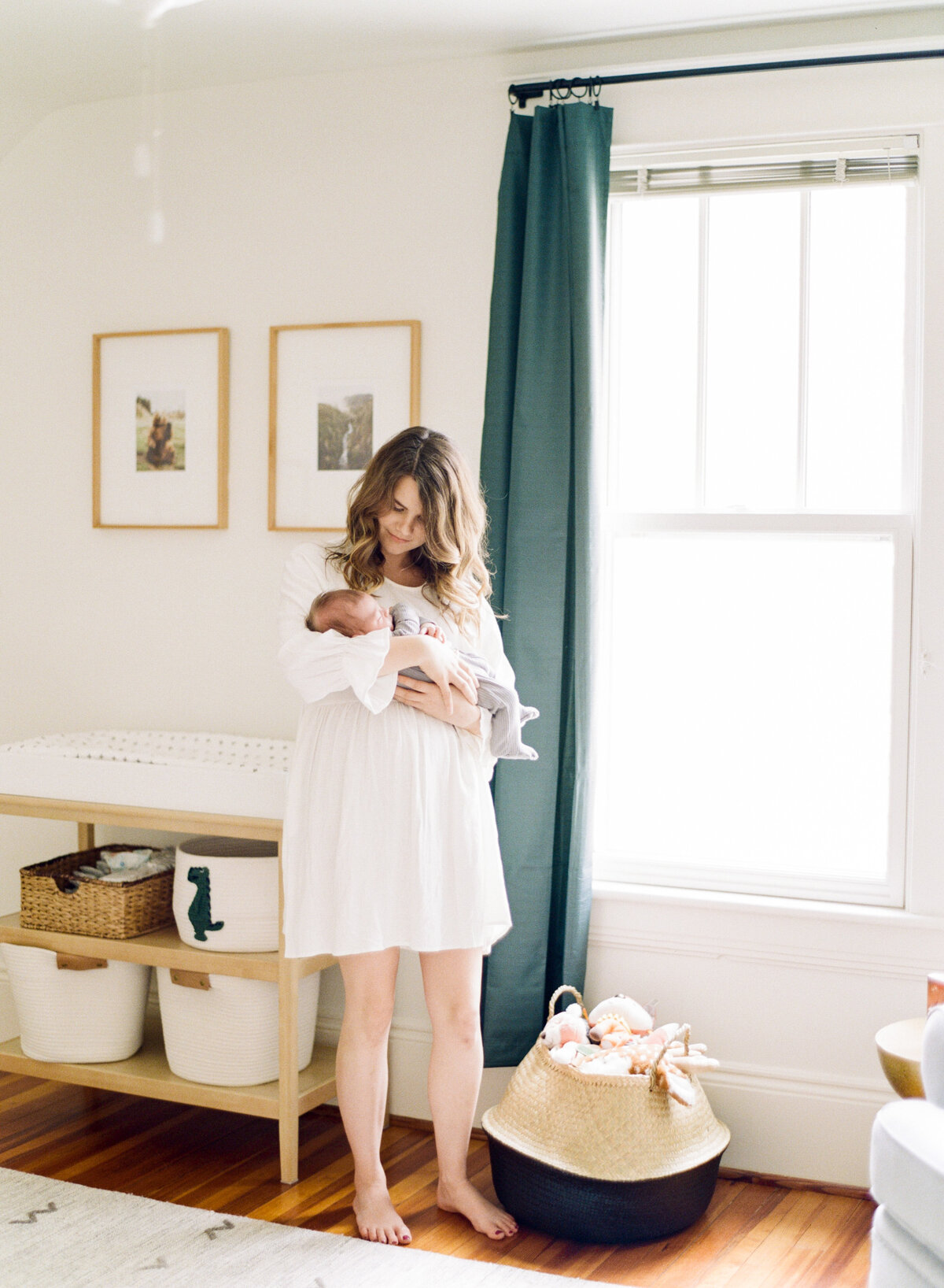 Mom stands in woodland nursery and holds her son in Raleigh newborn session. Image by Raleigh newborn photographer A.J. Dunlap Photography.