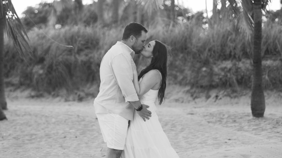 Romantic engagement photo of a couple kissing on the beach in Miami, captured by Claudia Amalia, a wedding and lifestyle photographer based in Miami and Florida Keys, South Florida. Specializing in destination weddings.