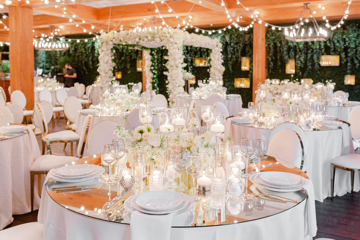 A chuppah decorated with fluffy white flowers matching the centrepieces at a wedding ceremony at Restaurant Beatrice. 