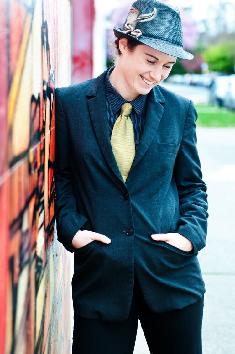 A person laughing and leaning against a wall