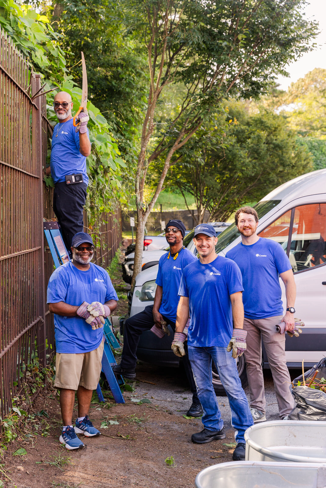 Cousins employees wearing matching blue tee-shirt helping City of Refuge by event photographer Laure Photography