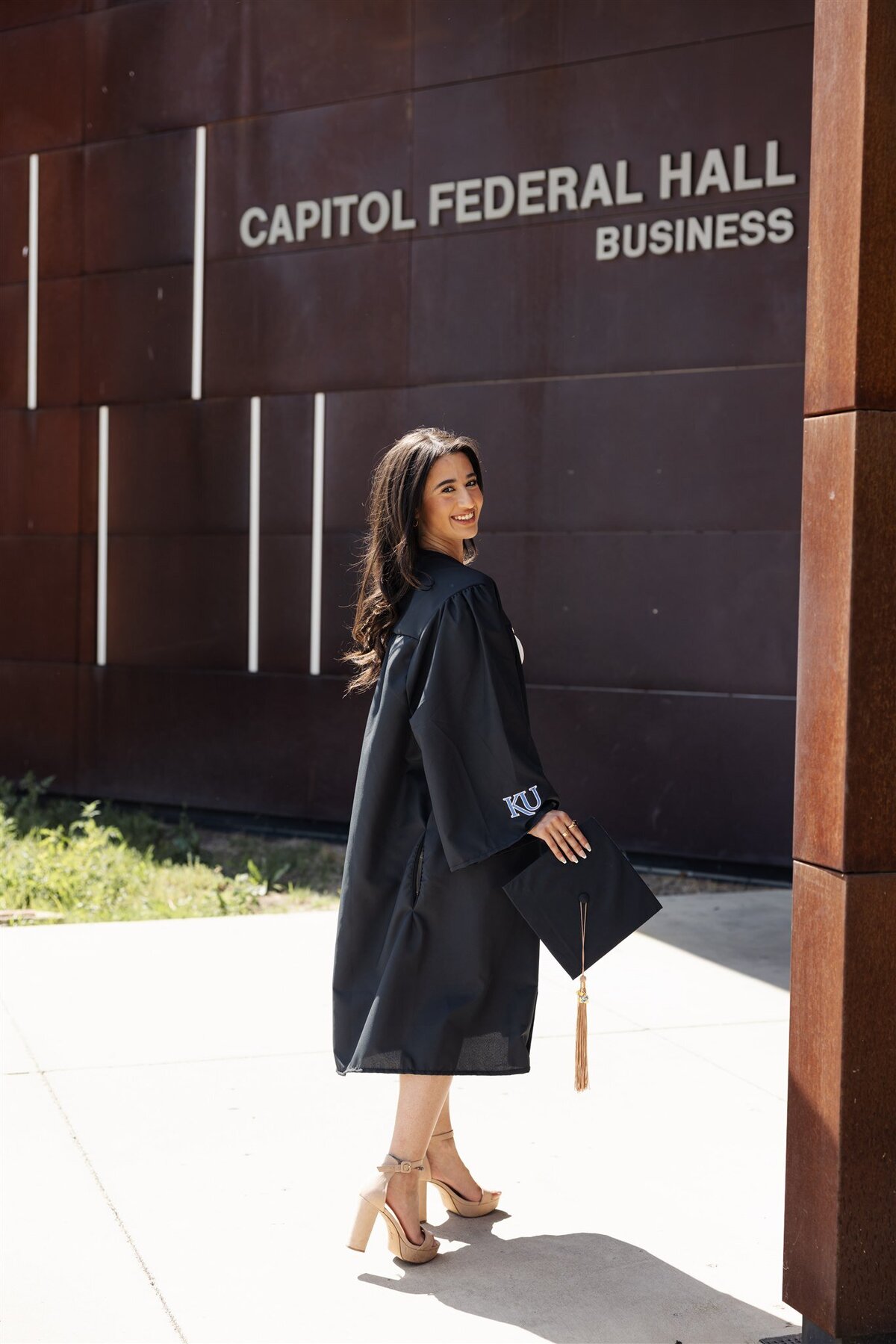 May graduation portraits outside brick building at golden hour