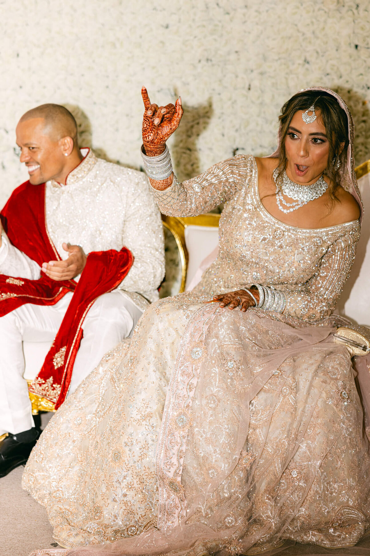 A candid wedding photo fo the bride and groom sitting beside each other dancing in Dublin Ireland