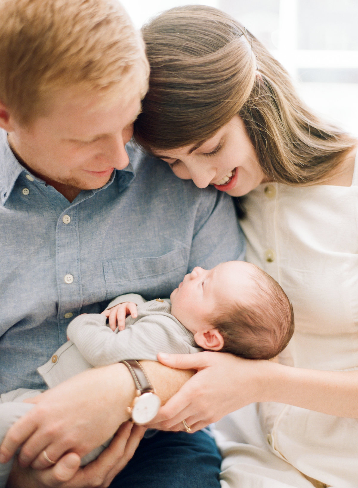 Mom and dad snuggle their newly adopted son during their Raleigh newborn session. Photographed by Raleigh Newborn Photographer A.J. Dunlap Photography.