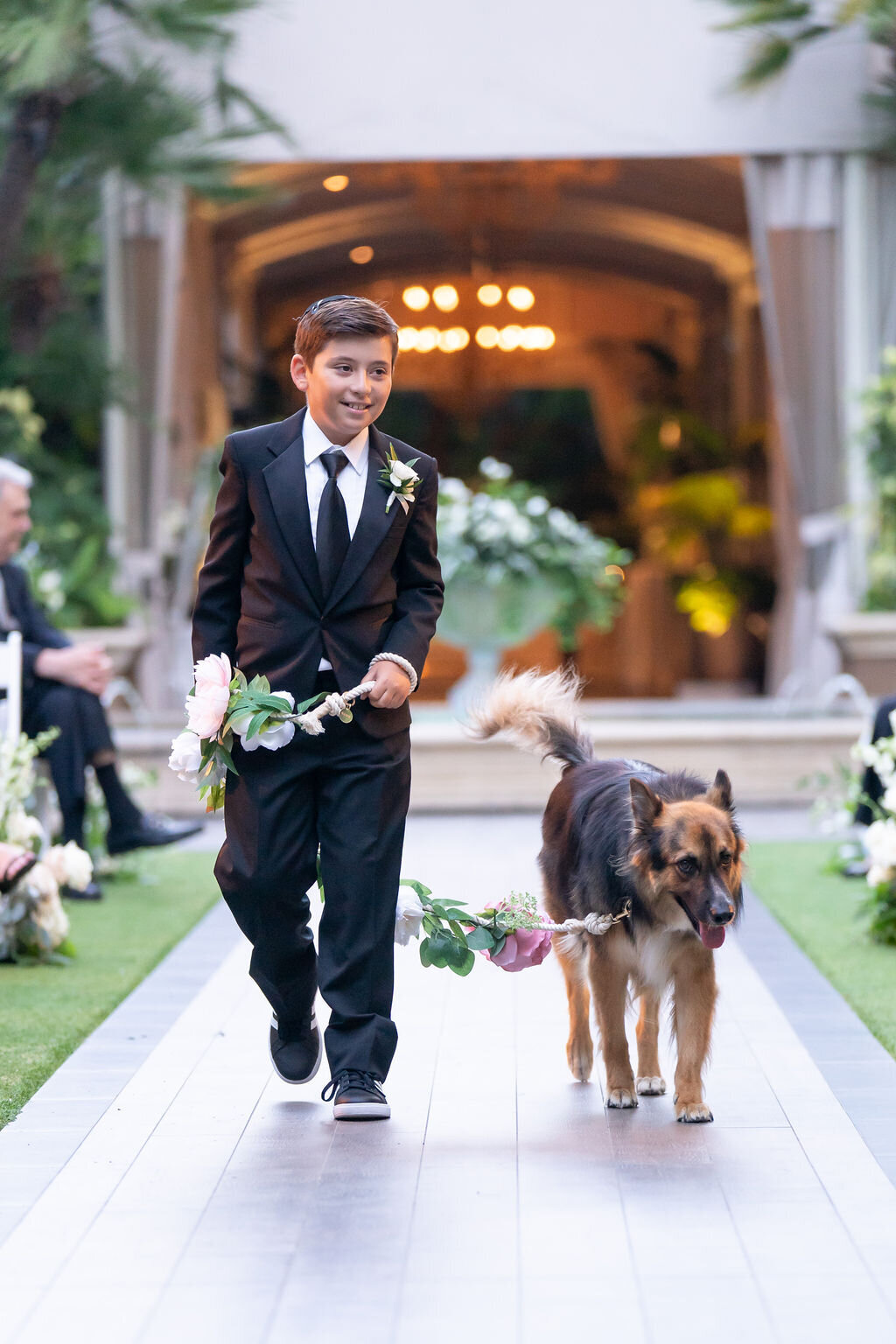 ring bearer walking in the couple's dog at ceremony