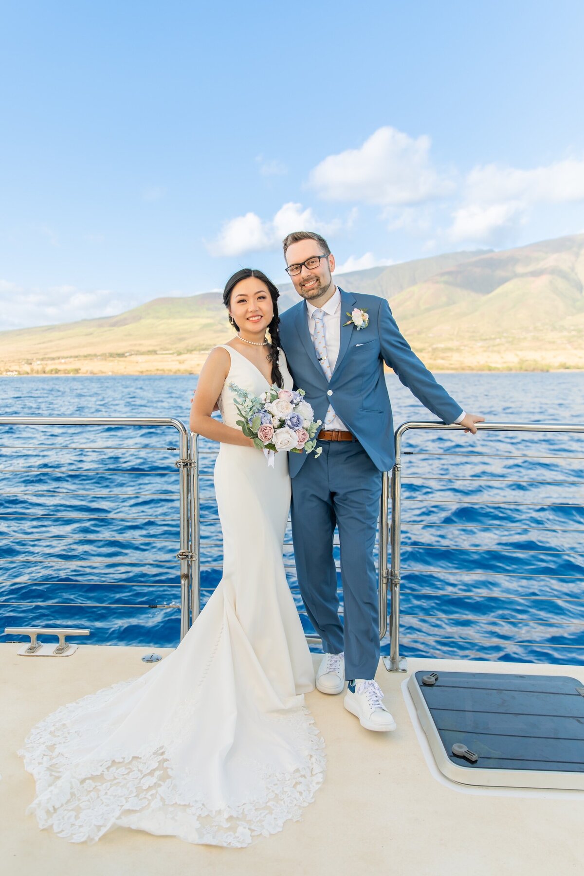 bride is wearing white dress and groom is wearing blue suit