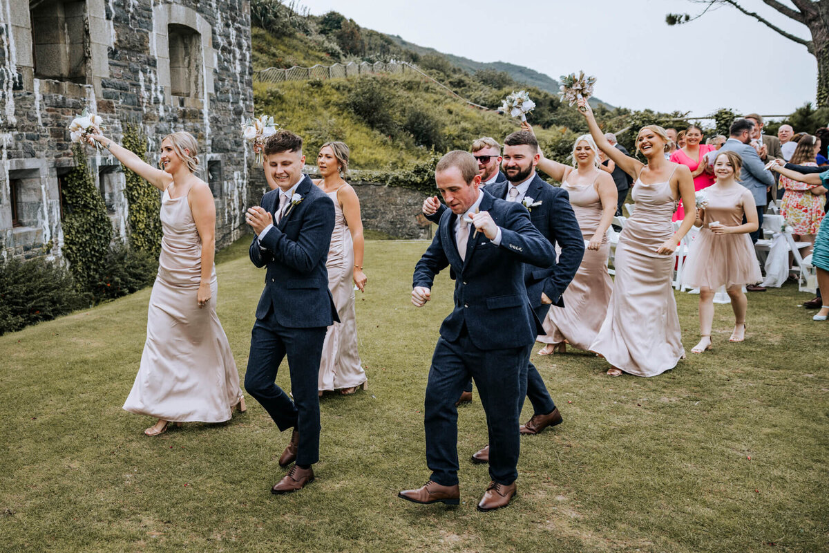 The wedding party dancing out of the ceremony