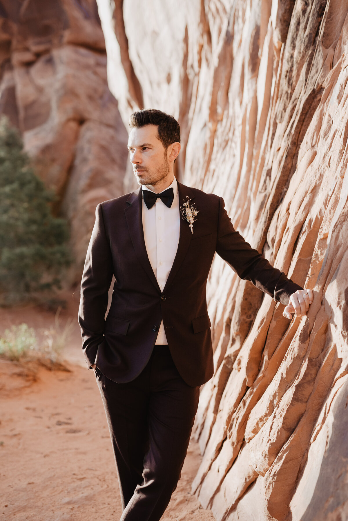 Utah elopement photographer captures groom looking away from red rock