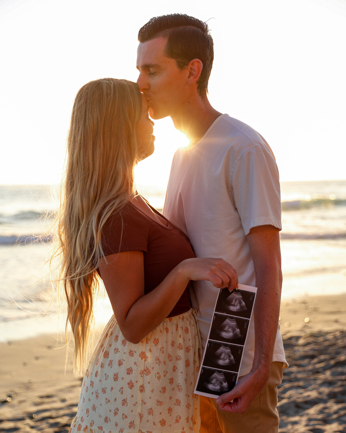 Intimate maternity moment with couple in San Diego holding ultrasound
