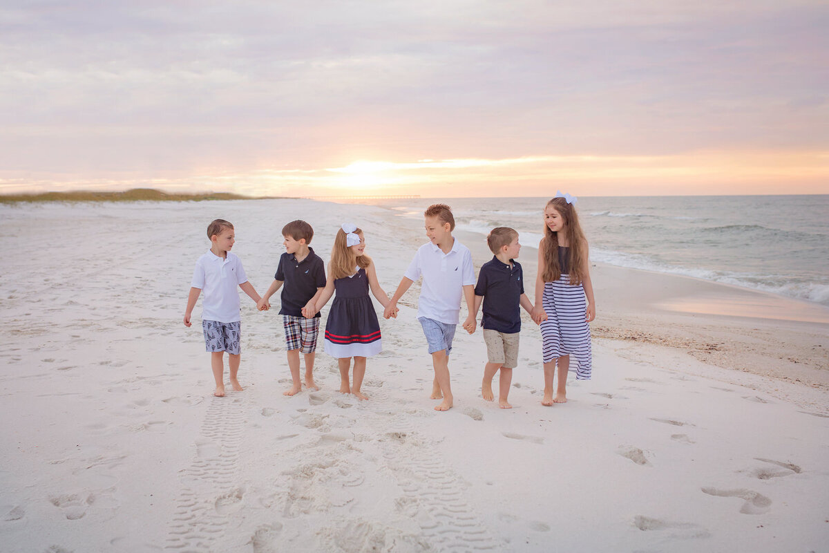 six-siblings-walking-on-beach-at-sunrise