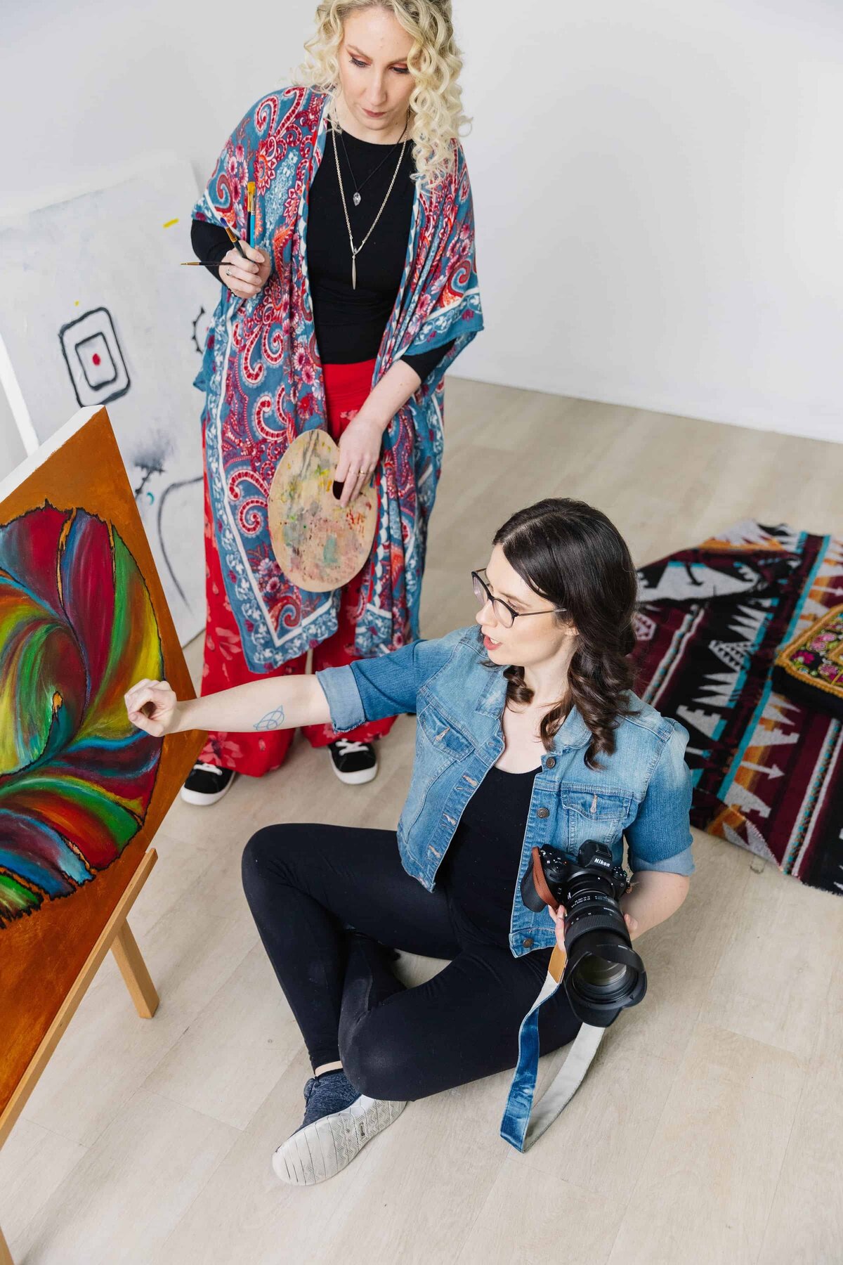 Alicia providing direction to artist client for how to pose while client is listening attentively