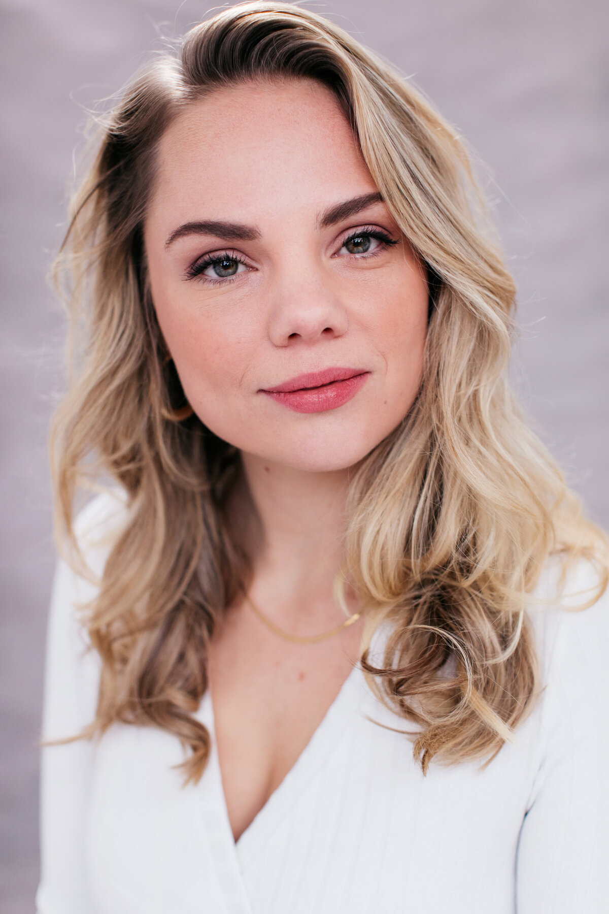 Castingfoto van zangeres Bernice Havenaar. Blond golvend haar, witte top en een sterke, open expressie.