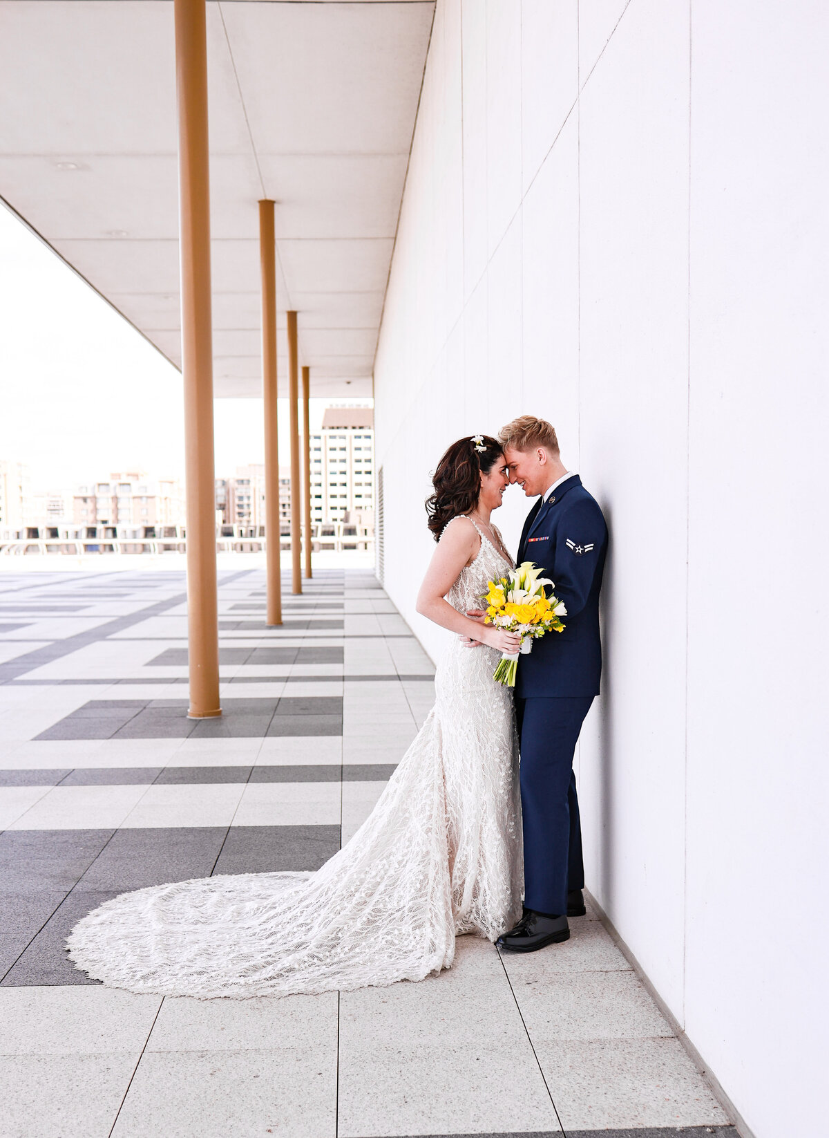 brides hugging each other wearing lace dress and Air Force uniform at their Washington DC elopement at The Kennedy Center by Amanda Richardson Photography