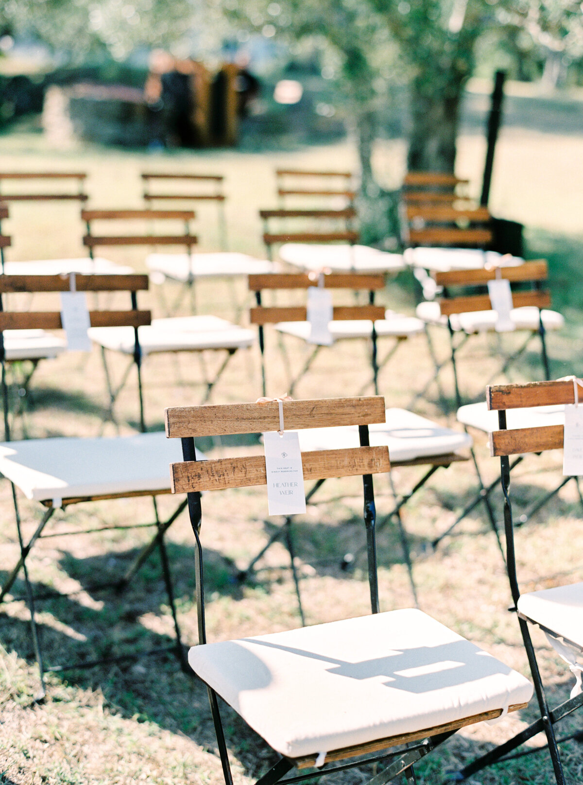 Film photograph of wooden wedding chair with name tags photographed by Italy wedding photographer at Villa Montanare Tuscany wedding