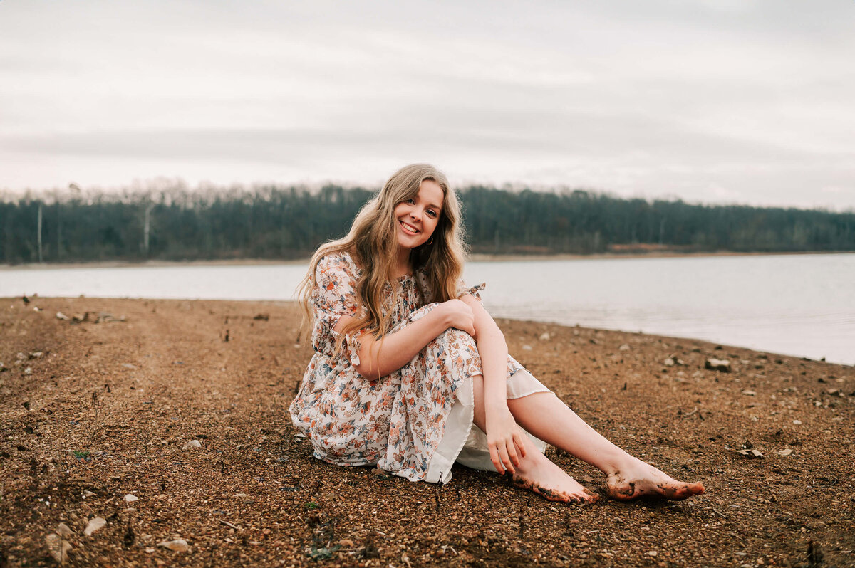 Branson Missouri senior photographer Jessica Kennedy of The XO Photogrpahy captures teen girl sitting in sand near the lake