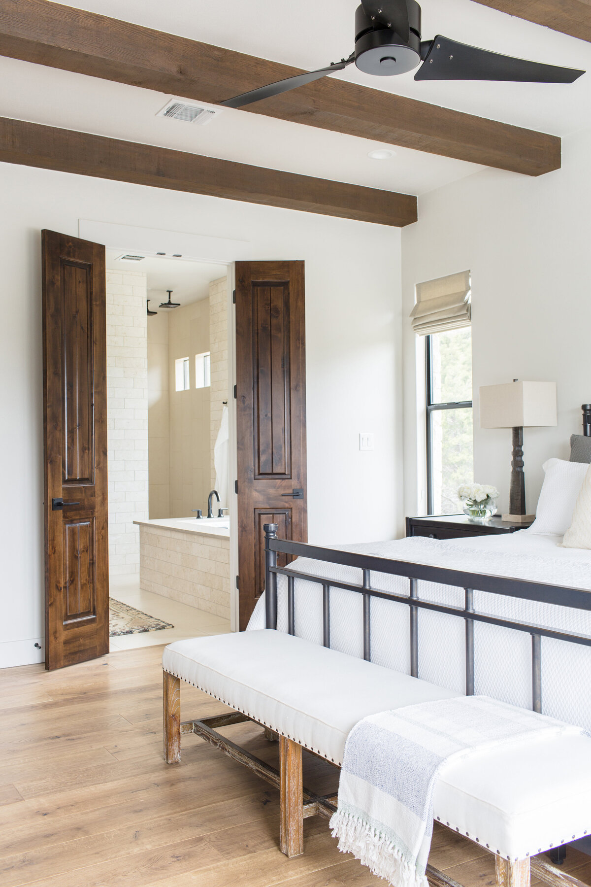 wood doors leading to bright and airy bedroom